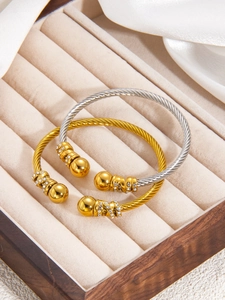 Détail de bracelets torsadés bicolores avec cristaux dans un coffret cadeau en velours