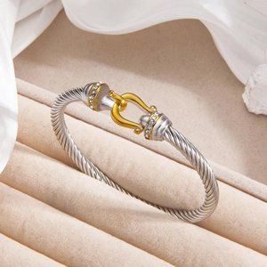 Two-tone cable twist bangle with 18k gold plated horseshoe clasp and crystal accents