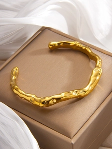 Detailed view of the gold-plated irregular liquid texture on the C-shaped open cuff bracelet