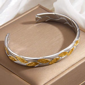Two-tone leaf patterned gold and silver bangle bracelet on a premium jewelry box