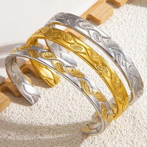Detailed relief of leaf patterns on gold and silver plated stainless steel bangles