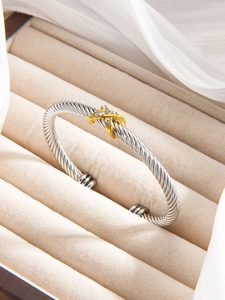 Close-up of cable twisted silver cuff bracelet with gold X crystal pave detail