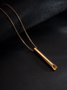 Détail du pendentif sifflet or rose avec surface polie et coupe oblique sur cuir