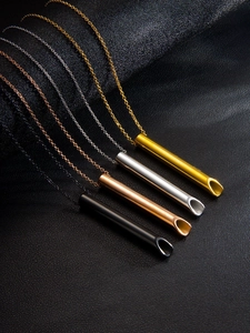 Pendentifs sifflets en or, argent, or rose et noir sur fond de cuir noir texturé