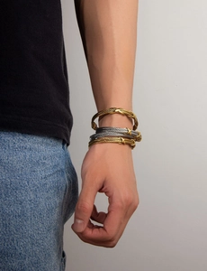 Detailed shot of cable-style twisted metal bracelets in gold and silver finish