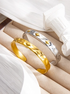 Detail of gold and silver hammered open bangles with embossed star patterns