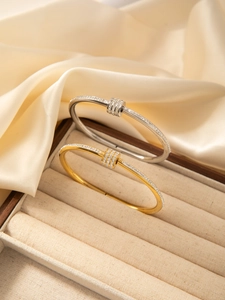 Detail of gold and silver plated bangles with micro-pave crystals on silk background
