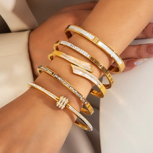 Set of five gold titanium steel bangles with shell inlay and Roman numerals