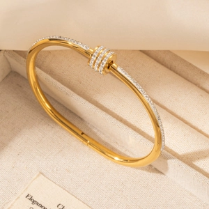 Elegant gold-plated waist-shaped bangle with micro-pave crystals on a beige jewelry box