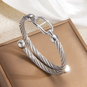 Macro detail of silver twisted cable bracelet with elegant metal horsebit buckle design