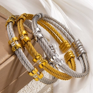 Close-up of twisted steel cable bracelets with H-shaped crystal encrusted buckles