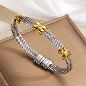 Detailed close-up of cable twist bracelet with diamond accents on gold and silver bands