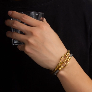 Detail of twisted cable bracelet with horseshoe clasp in 18k gold and silver finish
