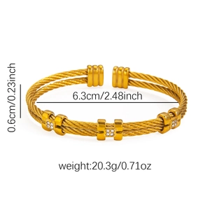 Detail view of twisted gold-tone steel cable bangle with dimensions and weight info