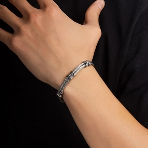 Macro view of a two-tone twisted cable bracelet with diamond accents and vintage buckle