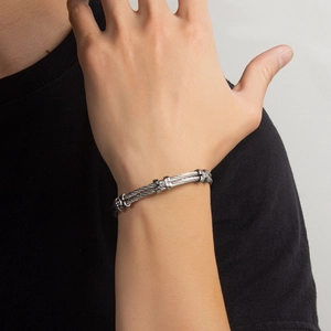 Detail of twisted cable steel bracelet with rhinestone square clasp on model wrist
