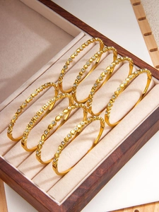 Achtteiliges Set goldener Armbänder mit Herz-, Kleeblatt- und Stern-Strasssteinen