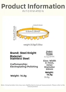 Detail view of gold stainless steel bangle with heart-shaped cubic zirconia inlay