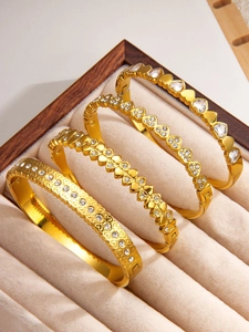 Close-up of golden heart-shaped titanium steel bangles with sparkling zircon inlays