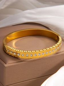 Detailed shot of gold titanium heart bracelet with sparkling zircon stones in a gift box