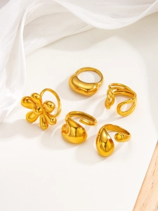 Macro shot of 18k gold plated stainless steel floral rings and liquid metal band set