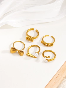 Detail shot of five adjustable 18k gold plated rings with pearls and bow accents
