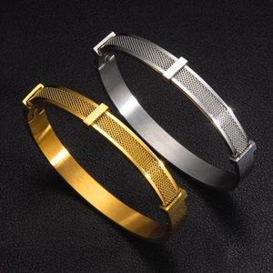 Detail shot of gold and silver mesh texture bangles on black leather background