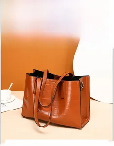 Detail view of orange-brown crocodile pattern tote bag with sturdy handles and D-ring