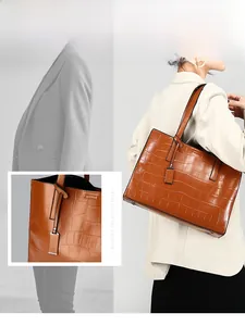 Close-up of brown crocodile texture tote bag with handle detail and model display