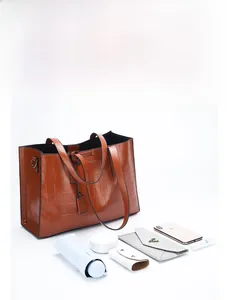 Macro shot of brown crocodile embossed tote bag showcasing large capacity and leather texture