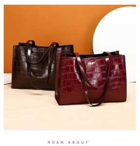 Close-up of high-gloss crocodile pattern texture on deep coffee and burgundy tote bags