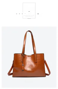 Detailed view of khaki tote bag with crocodile texture and reinforced stitching handles