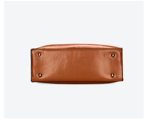 Detail view of handbag bottom with protective silver metal studs and crocodile texture