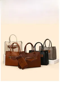 Detail view of large tote bags in various colors and a matching crocodile texture wallet