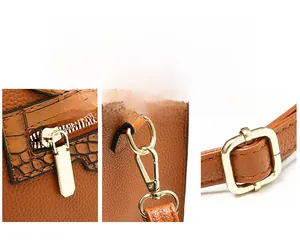 Detail of brown lychee grain leather, premium golden hardware, and zippers on a tote bag