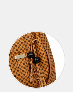 Detail of vintage flower pattern handbag featuring tassel and glossy black bead charm