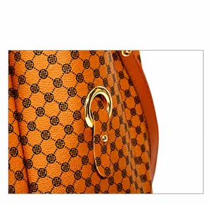 Detail of lychee textured leather bag with floral print and gold metal ring hardware