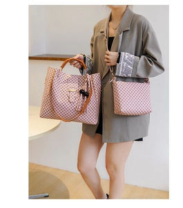 Detailed close-up of pink checkered tote bag set with brown handles and tassel charm