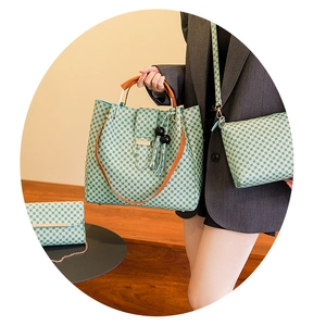 Close-up of a three-piece women's handbag set featuring light green plaid and brown leather