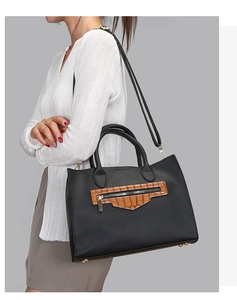 Detail of black pebbled leather tote with brown croc-pattern pocket and golden hardware