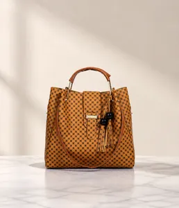 Front view of large brown tote bag with geometric pattern and tassel charm detail