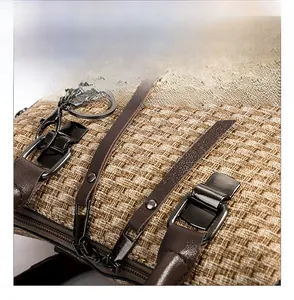 Detail of dual zipper closure on a tan woven tote bag with long leather pullers