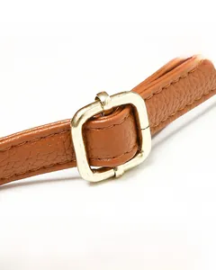 Close-up of caramel lychee leather strap with gold buckle and precise stitching
