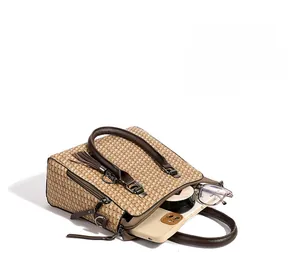 Macro view of woven handbag interior capacity with smartphone, glasses, and makeup compact