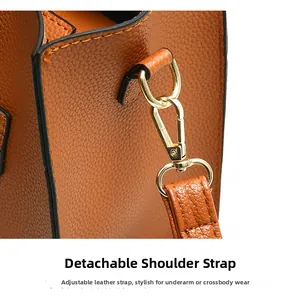 Close-up of brown lychee leather tote with gold hooks and adjustable shoulder strap