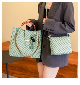 Detail of mint green tote bag set with geometric patterns and tassel charm on a bench