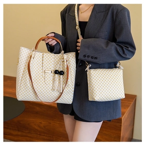 Detail of yellow geometric pattern tote bag with leather handles and tassel accent