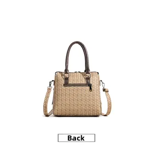Detailed back view of woven handbag showing leather strap and functional zipper pocket