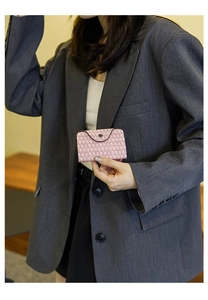 Close-up of pink and white tweed mini wallet with a charcoal grey round snap button
