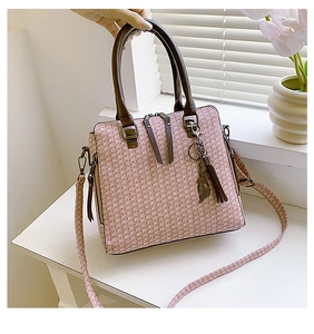 Detail of embossed multi-piece handbag with cat charm and detachable shoulder strap